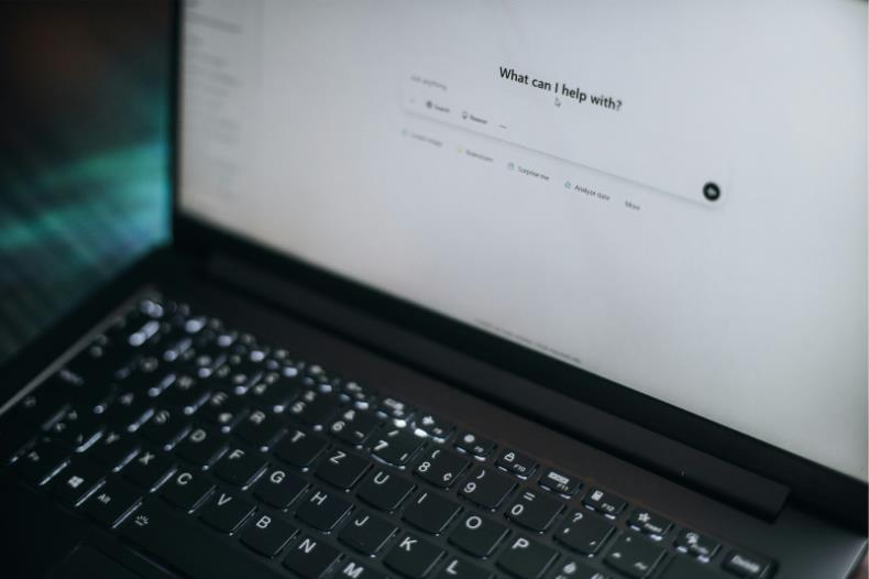 Laptop showing a prompt-first conversational interface with a central ask field and suggestion chips