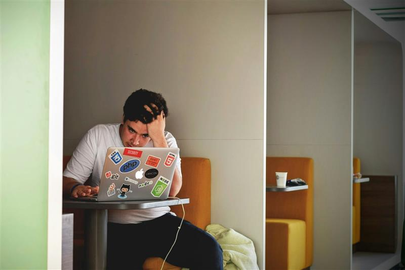 Positioning Is a Product Decision article cover: frustrated developer at a sticker-covered laptop